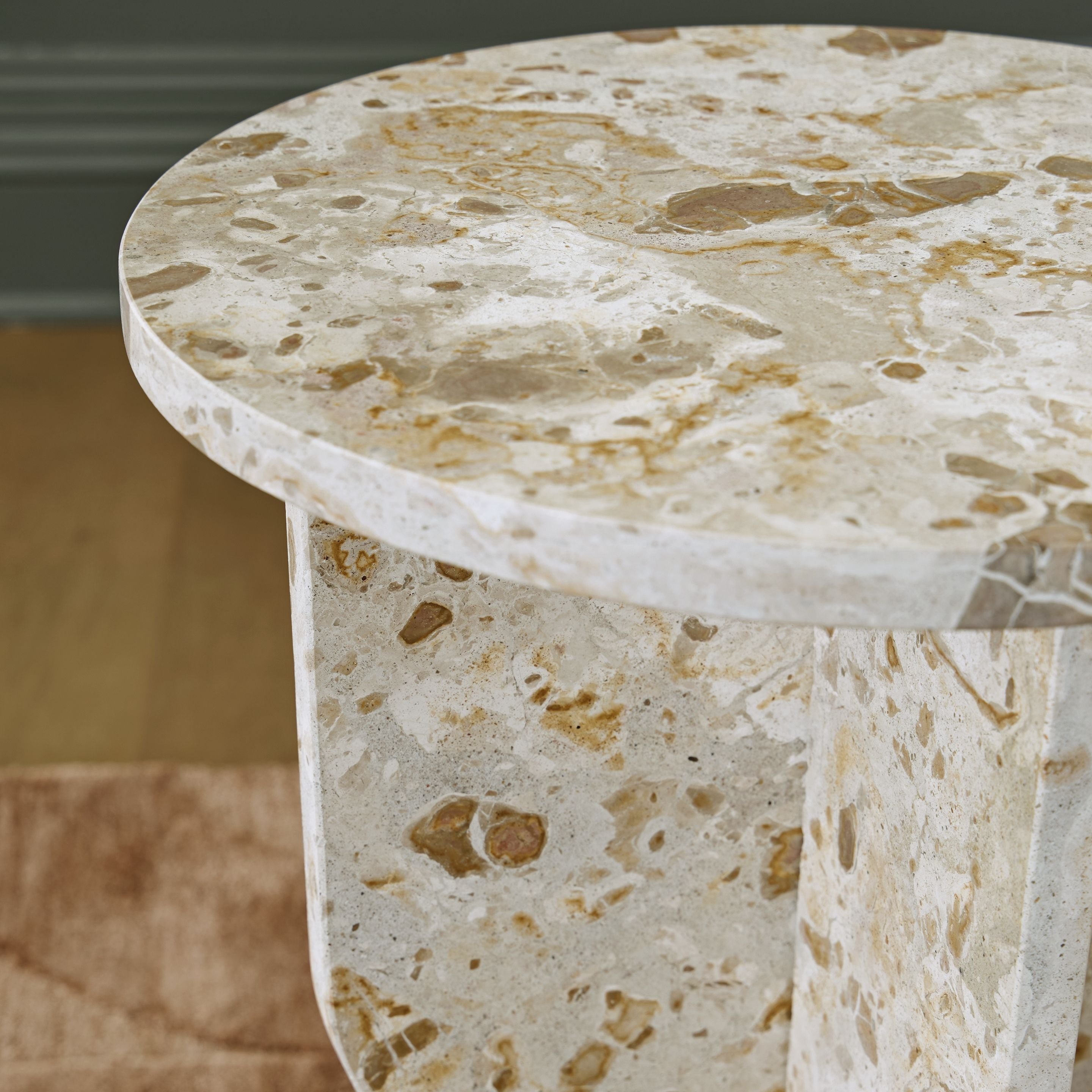 Beige stone-look accent table: close-up of round tabletop and pedestal edge