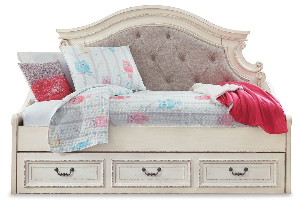 Chipped white twin day bed with tufted gray headboard, patterned quilt, red throw, pillows
