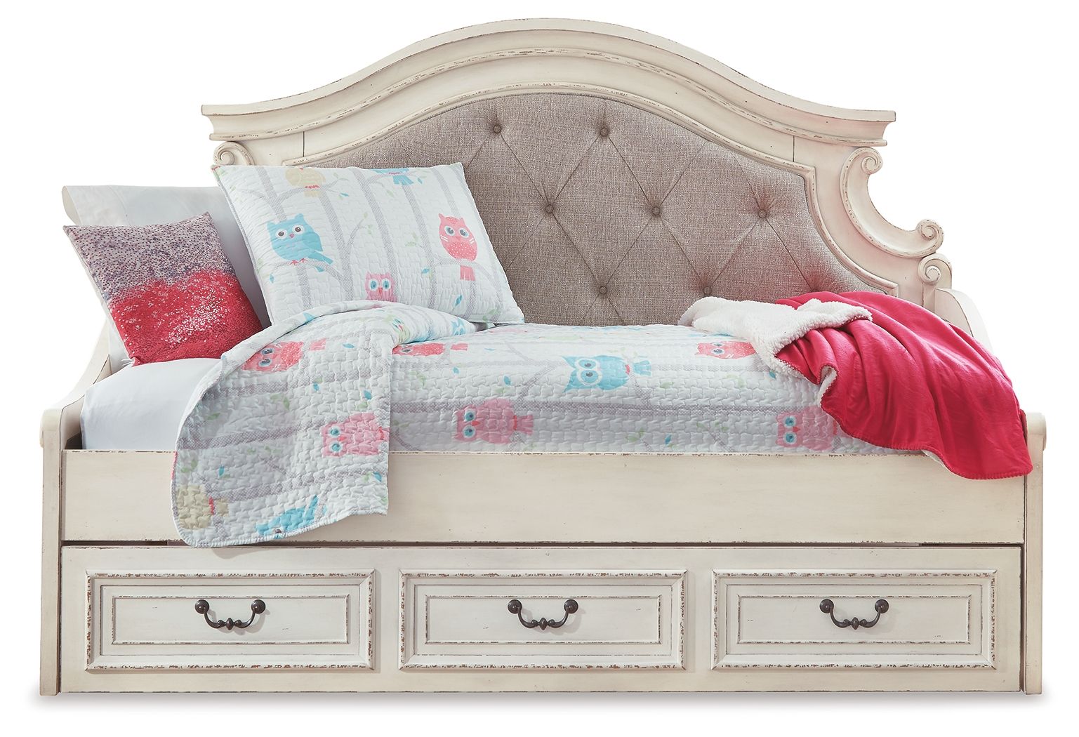 Chipped white twin day bed with tufted gray headboard, patterned quilt, red throw, pillows