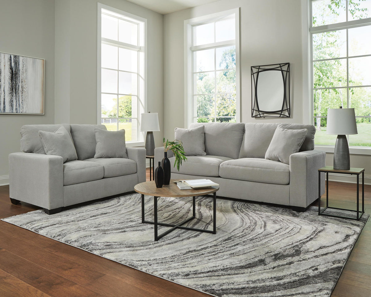 Gray upholstered sofa and loveseat set with square arms and accent pillows