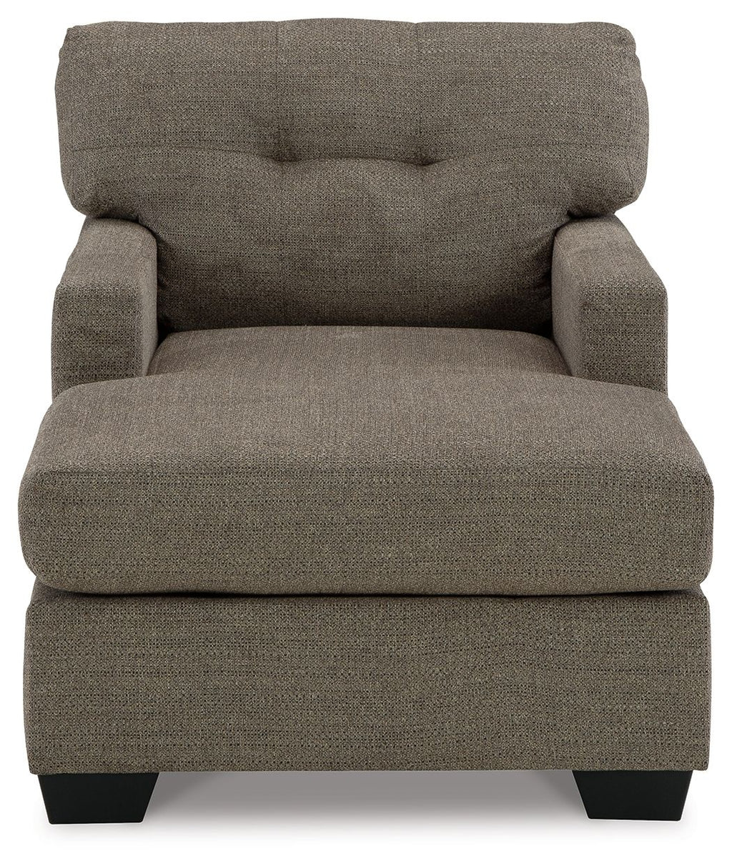 Dark brown upholstered chaise chair with tufted back, padded seat, and black feet