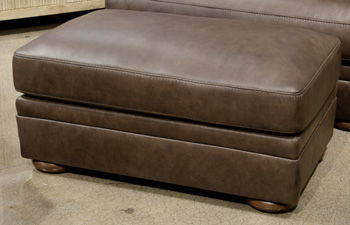 Brown upholstered ottoman with cushioned square top and tapered wooden legs