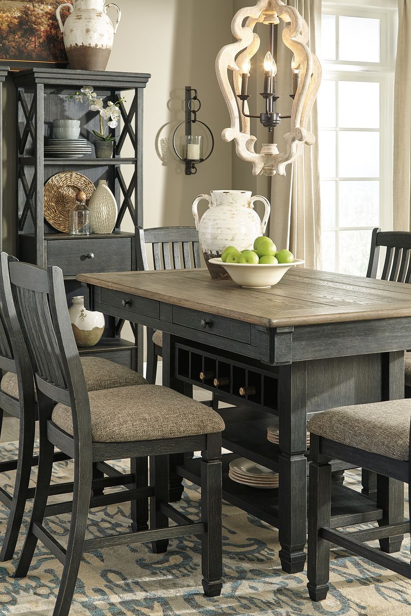 Dark gray counter height dining table with two slat-back bar stools and open shelf