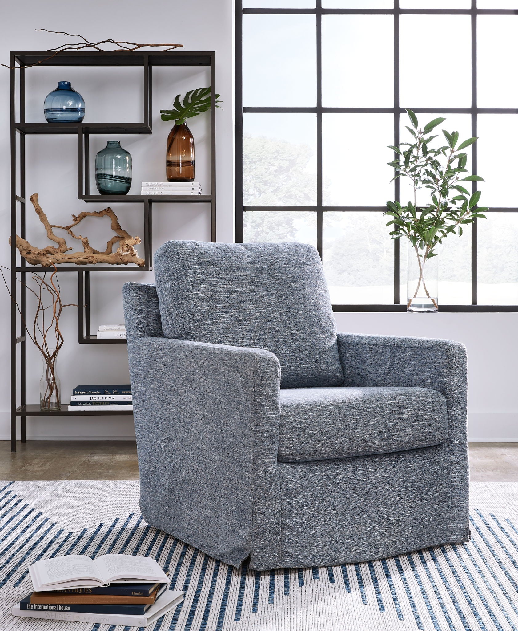 Blue upholstered swivel glider accent chair with rounded back and wide armrests