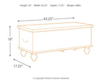Beige storage bench with carved front panel and hinged top for storage