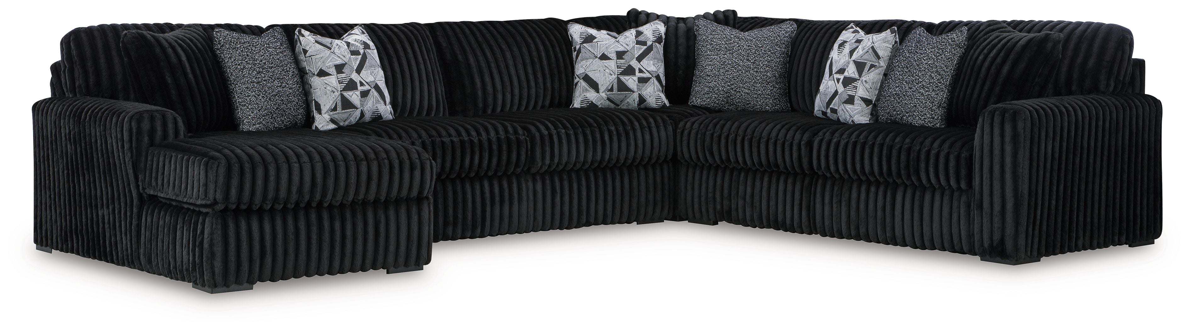 Black sectional sofa with chaise and ribbed design, styled with four patterned pillows