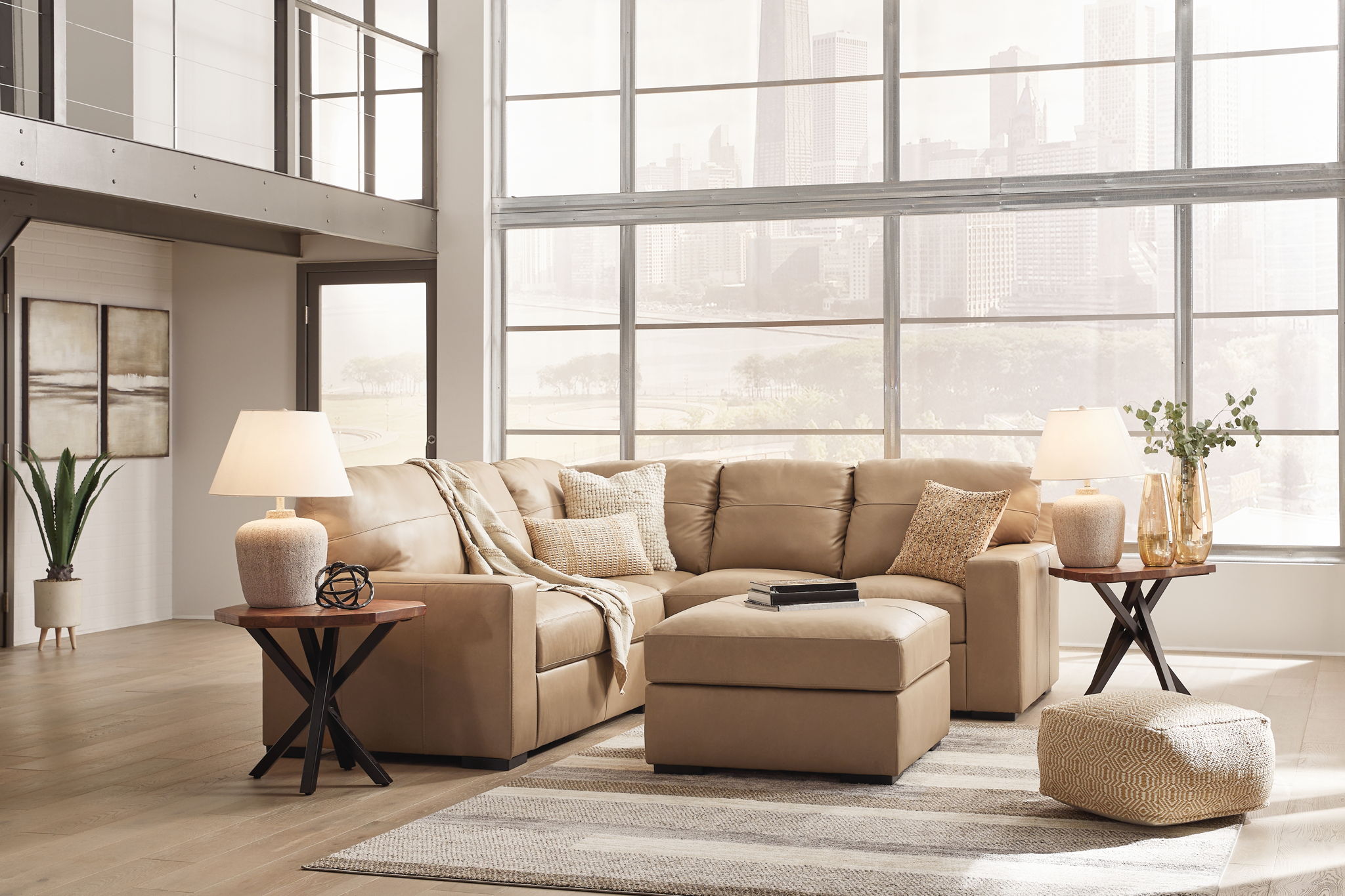 Light brown fabric sectional sofa with chaise and ottoman, accented with throw pillows