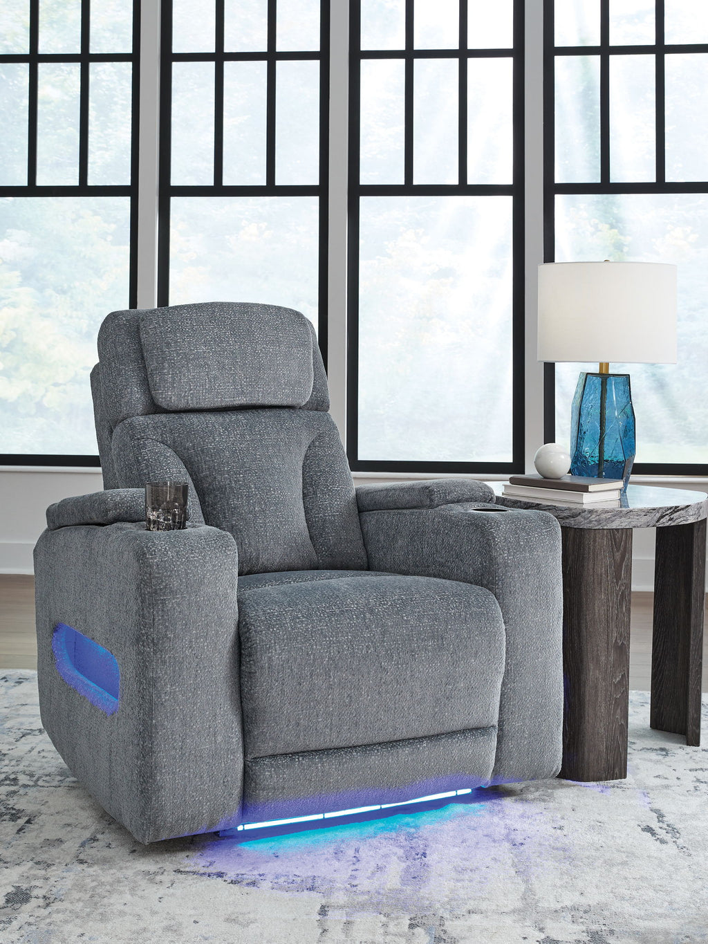 Dark gray fabric power recliner with padded armrests and headrest, glowing base light