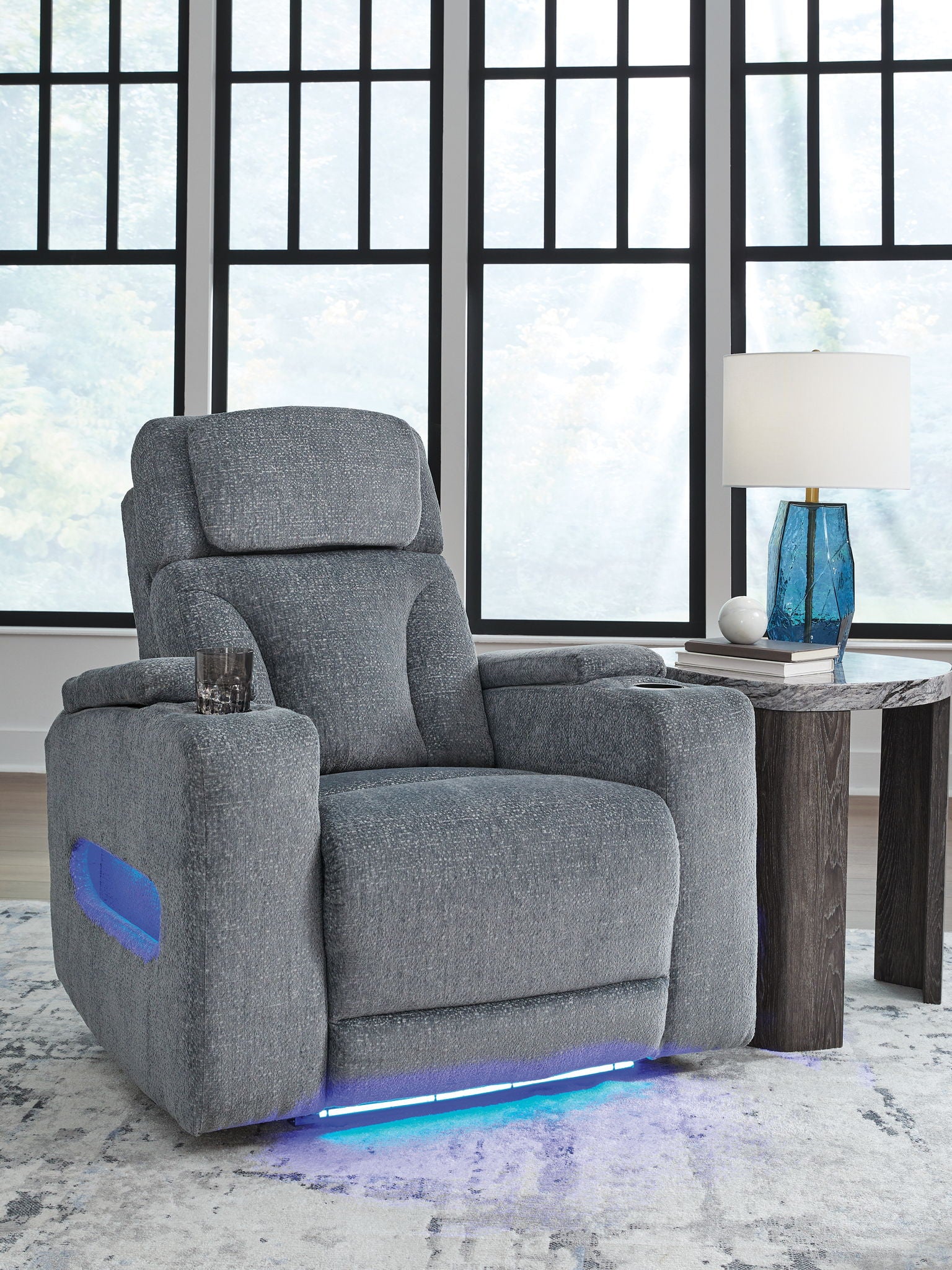 Dark gray fabric power recliner with padded armrests and headrest, glowing base light