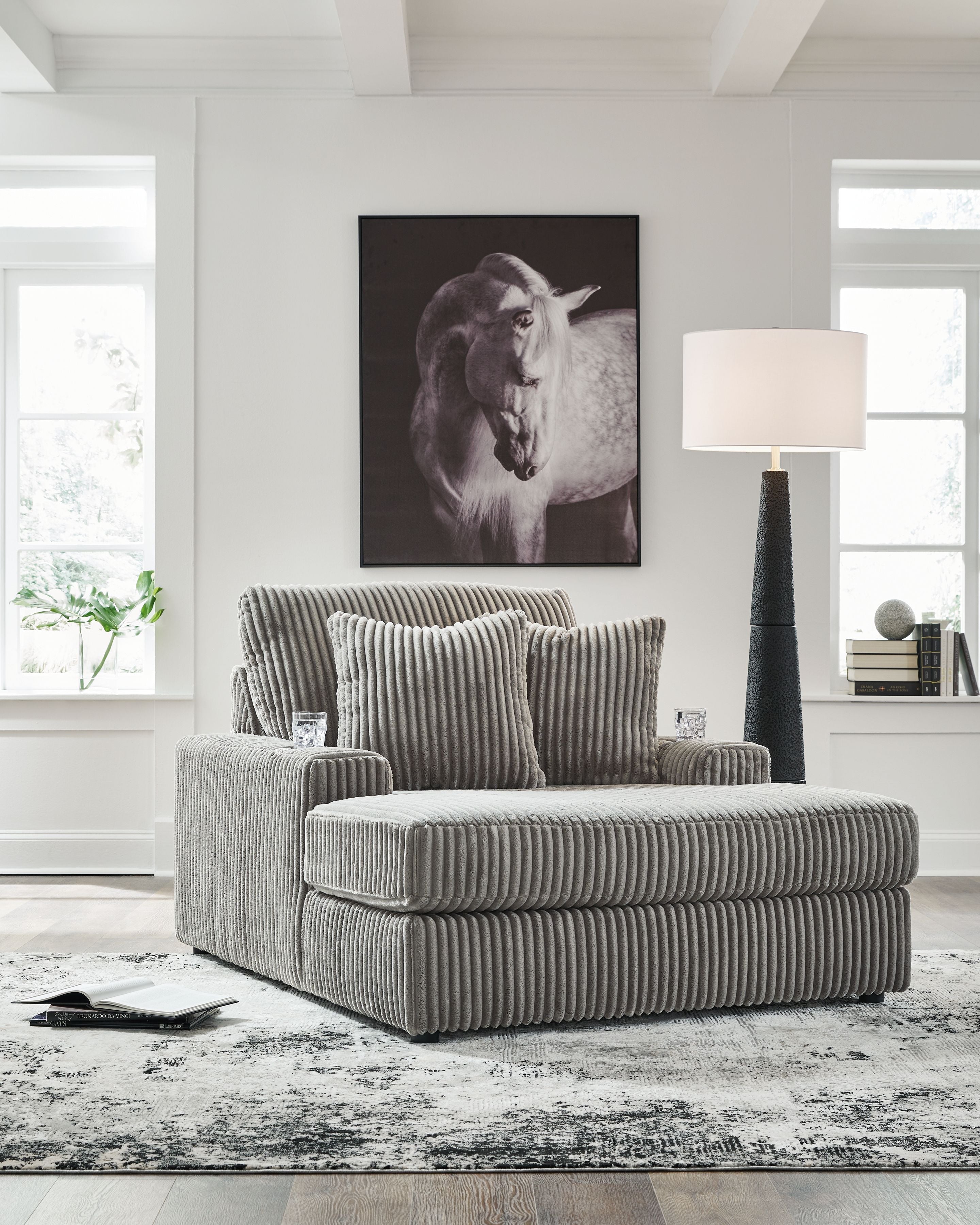 Corduroy chaise lounge chair in light gray with striped texture and two back cushions.