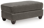 Gray fabric ottoman with upholstered top, square shape, and dark wood legs.