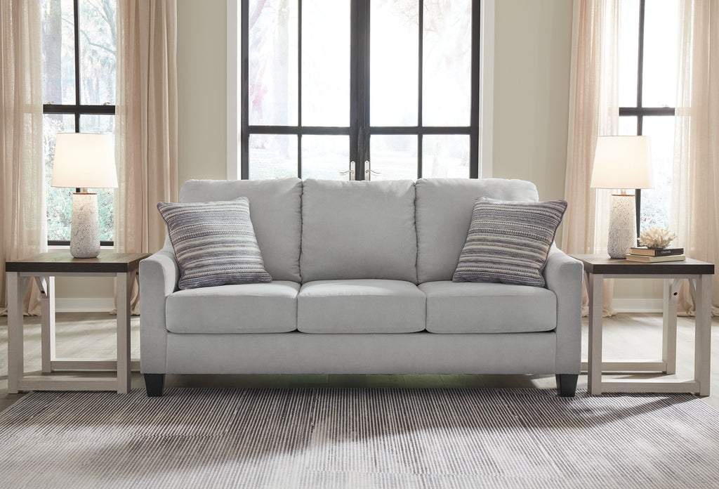 Gray fabric sofa with three seat cushions and two striped throw pillows