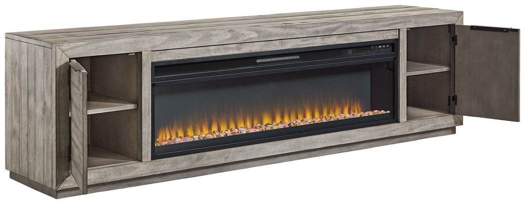 Gray TV stand with wide fireplace insert, side cabinets open to reveal shelves