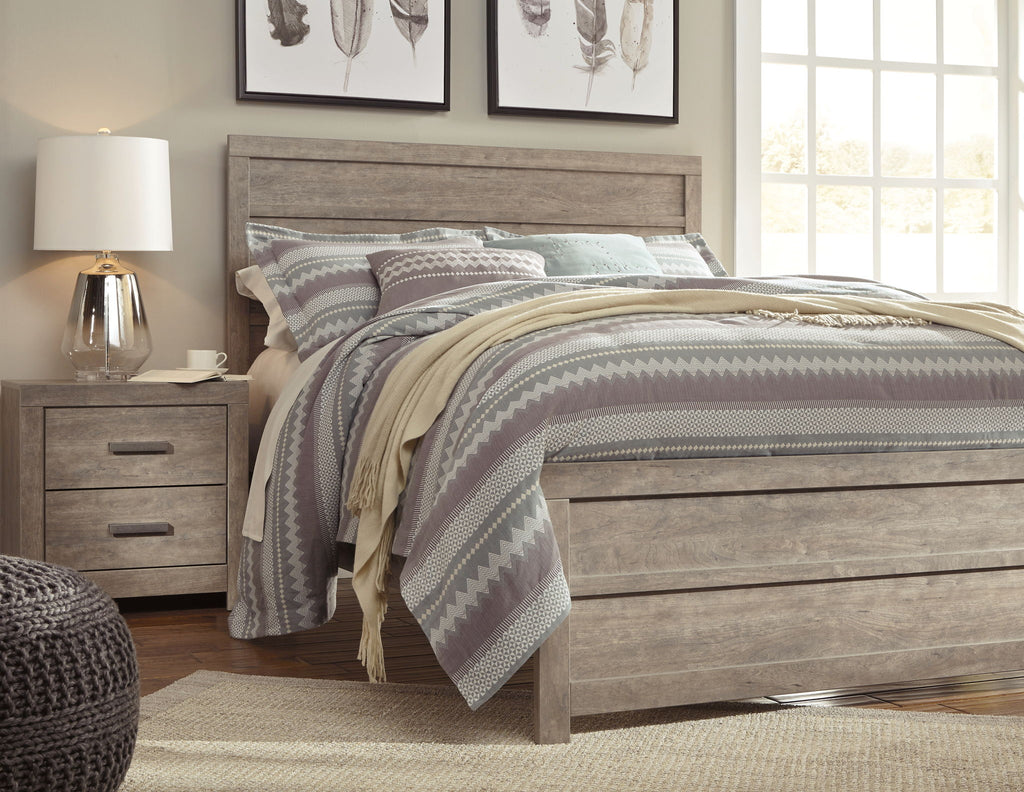 Gray panel bed frame with tall headboard, styled with striped and solid bedding