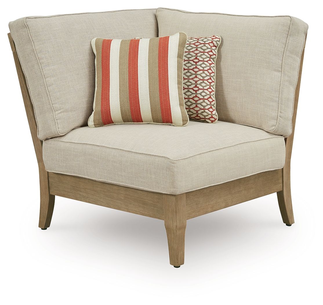 Beige fabric corner chair with two patterned throw pillows