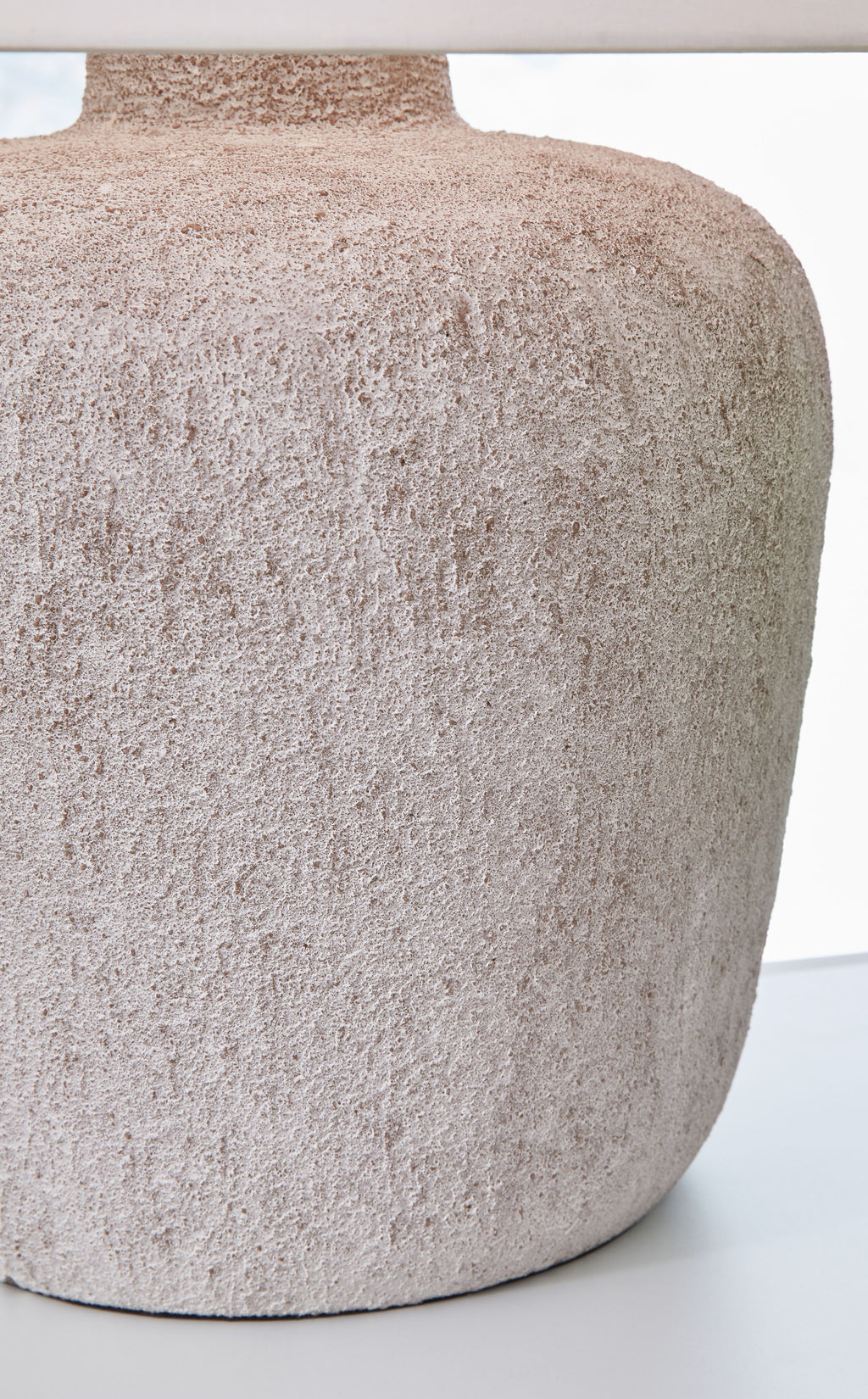 Textured gray stone-look lamp base with metal pedestal and round silhouette