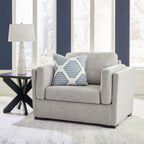 Gray armchair with wide arms and a striped throw pillow