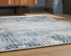 Blue and white abstract rug edge with tightly bound border and flat pile