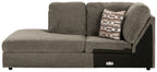 Gray corner chaise with back cushions, patterned pillow, and black side panel