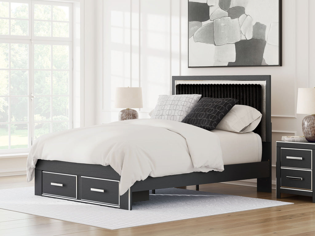 Dark upholstered platform bed with storage drawers, panel headboard, bedding on top