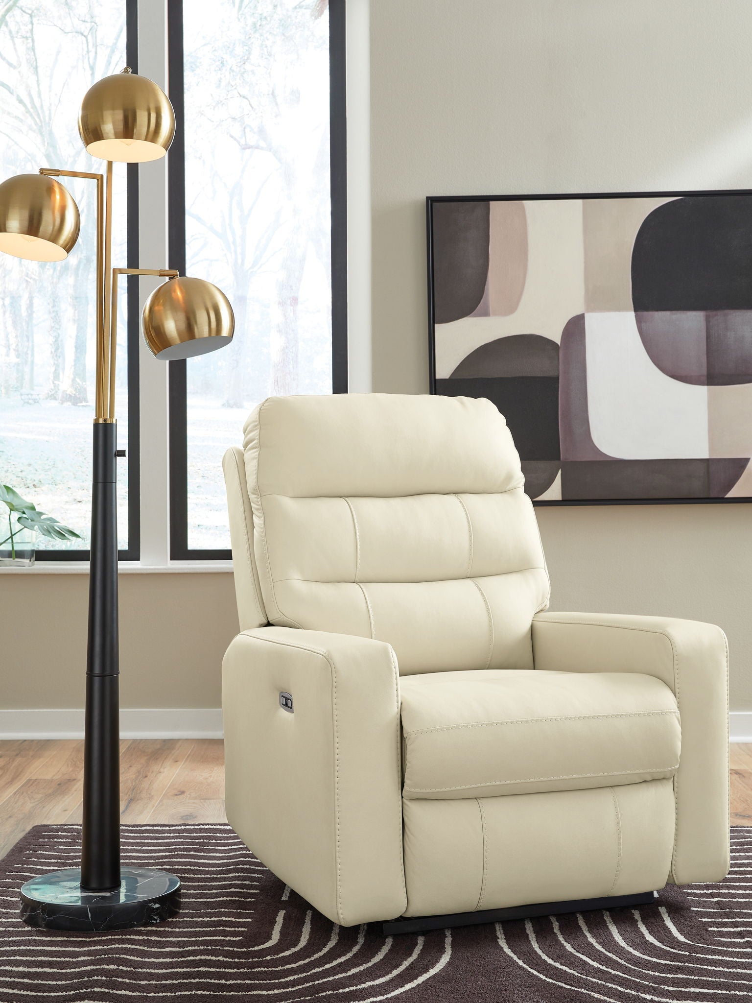 Power recliner with adjustable headrest in cream upholstery, wide arms and cushioned seat