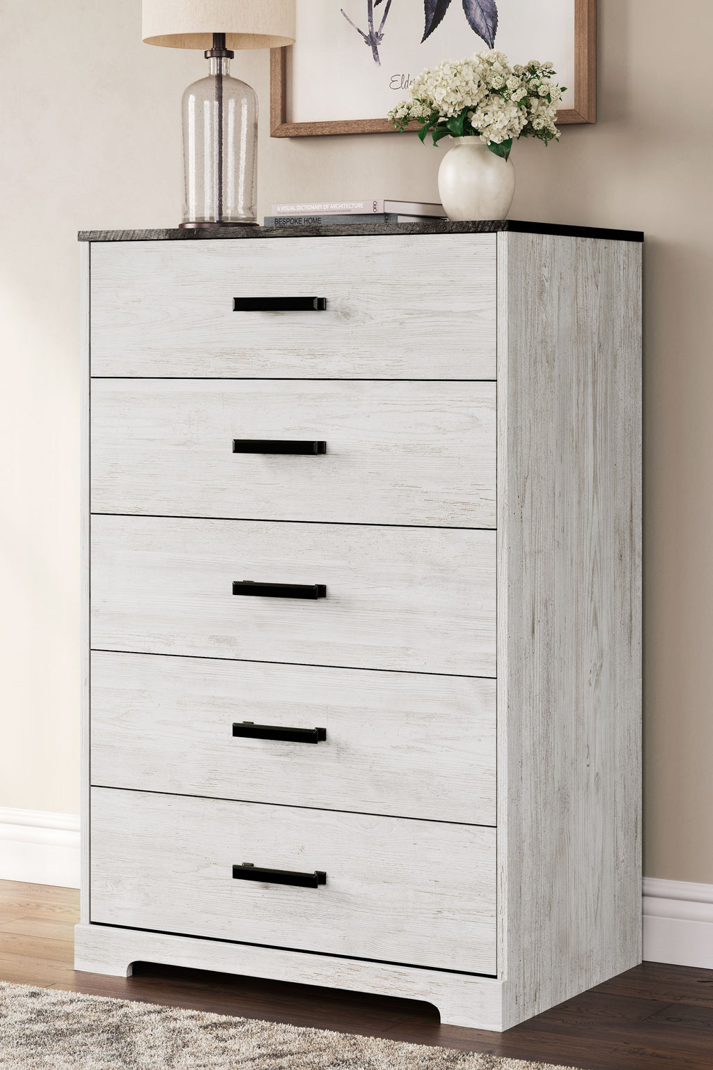 Whitewash drawer chest with five drawers and black bar handles, side view