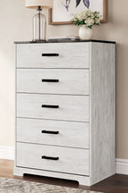 Whitewash drawer chest with five drawers and black bar handles, side view