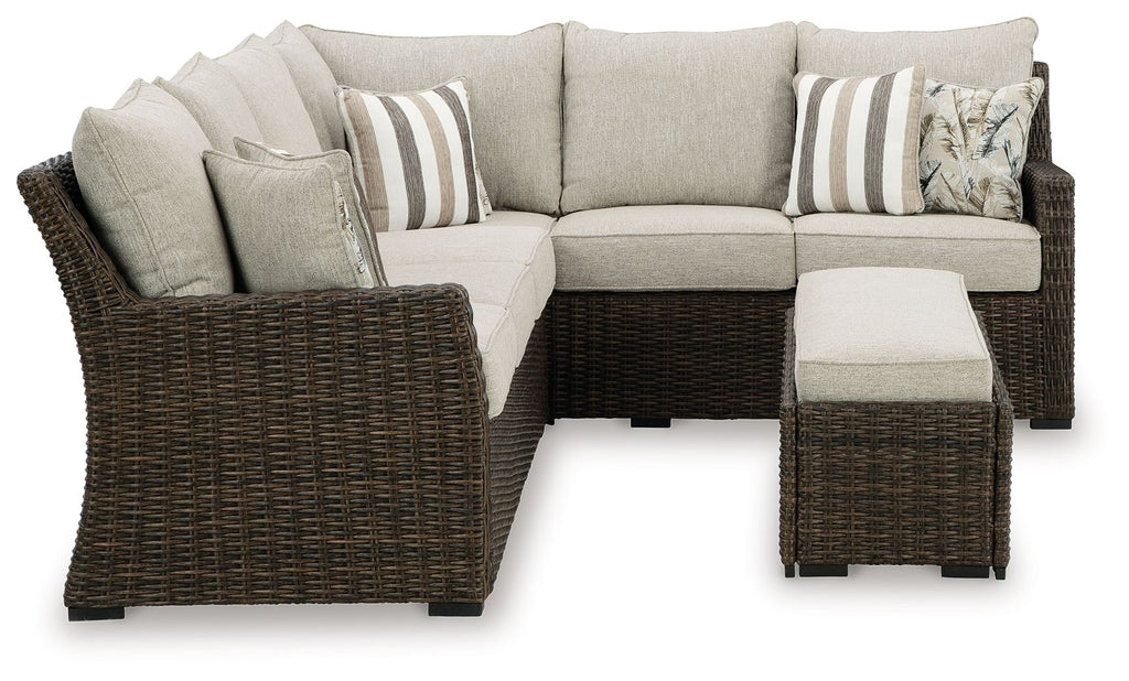 Brown wicker sectional sofa with beige cushions and ottoman benches