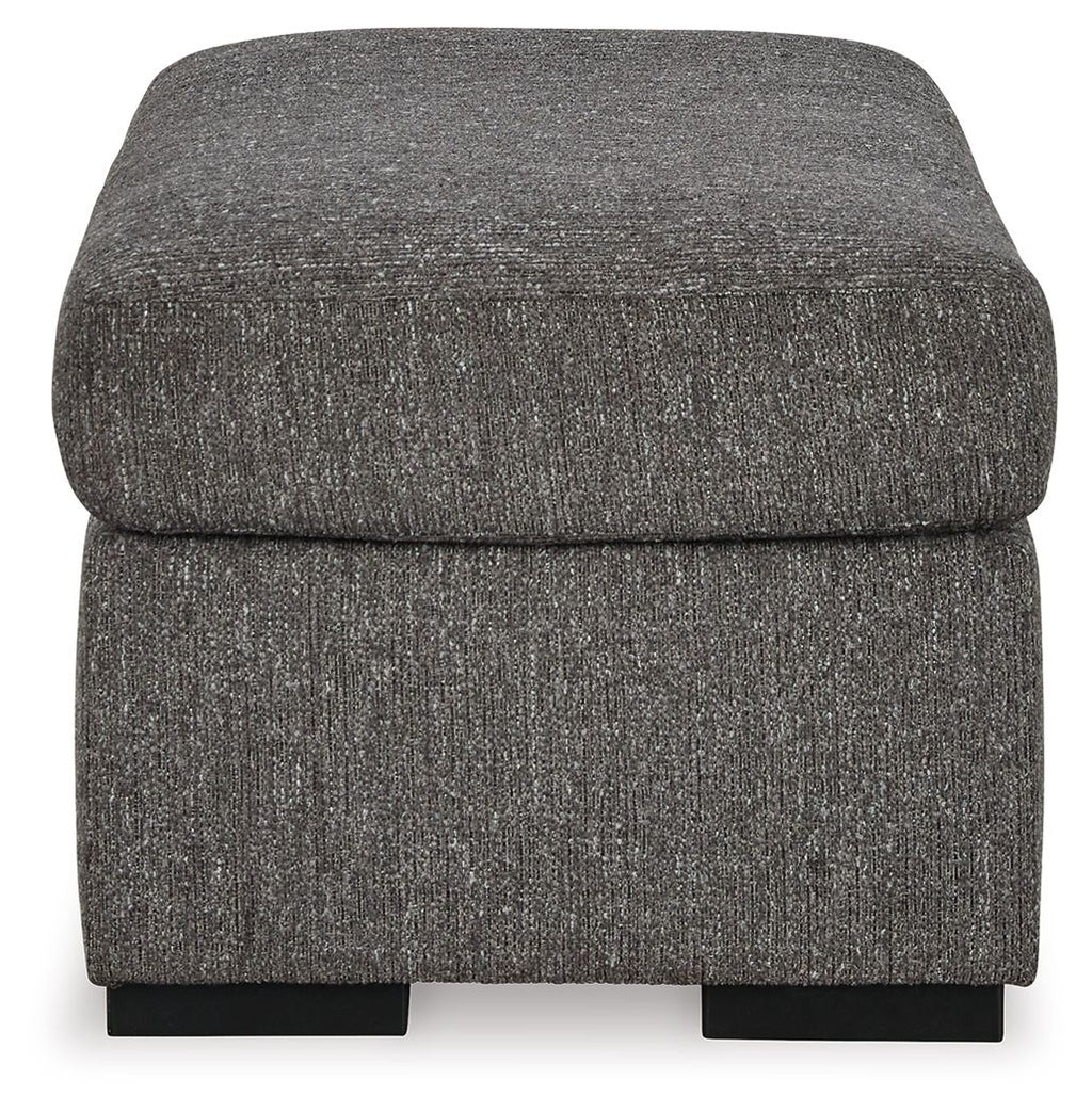 Pewter upholstered ottoman with rounded sides and black base