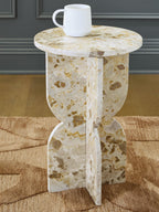 Beige stone-look accent table with round top and white mug on top