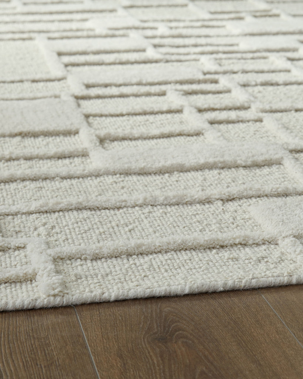 Empriss beige rug with stitched horizontal block lines and textured weave