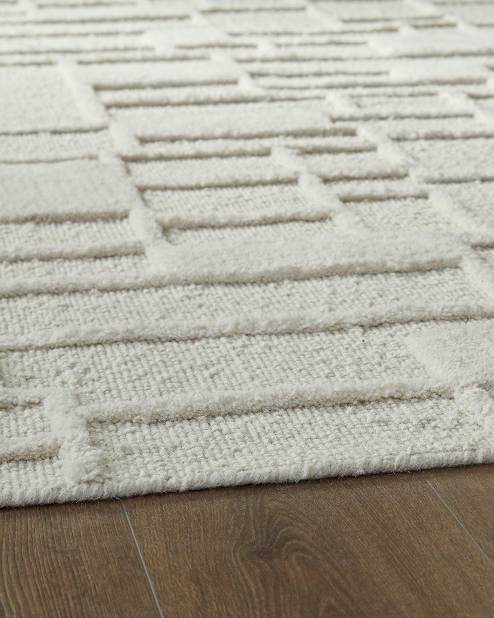 Empriss beige rug with stitched horizontal block lines and textured weave