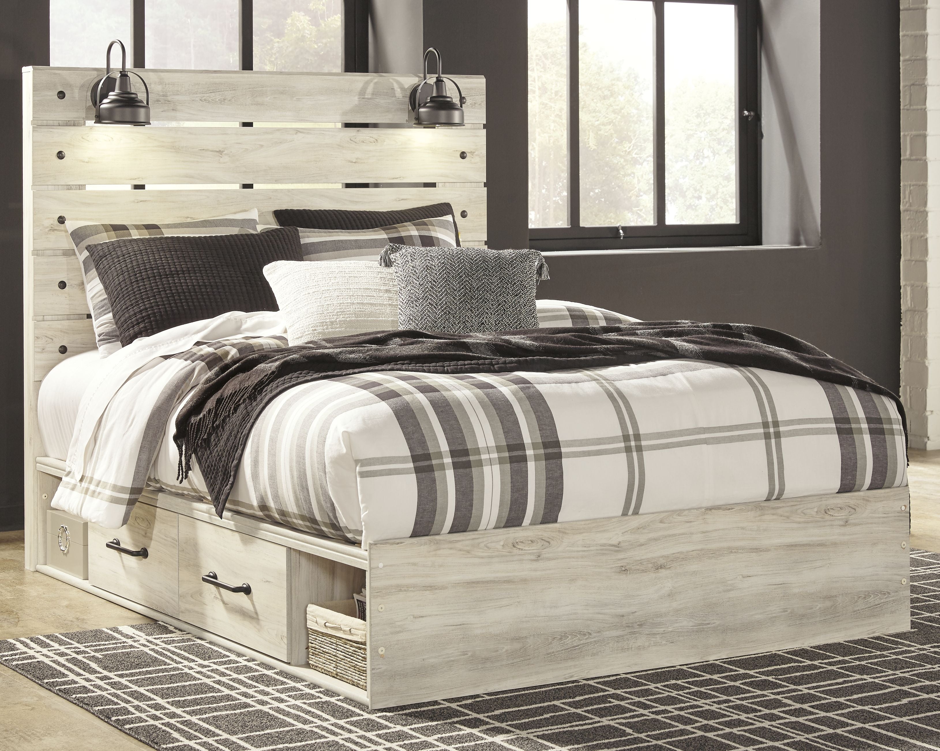 Light wood bed with plaid bedding and matching dresser with drawers and framed mirror
