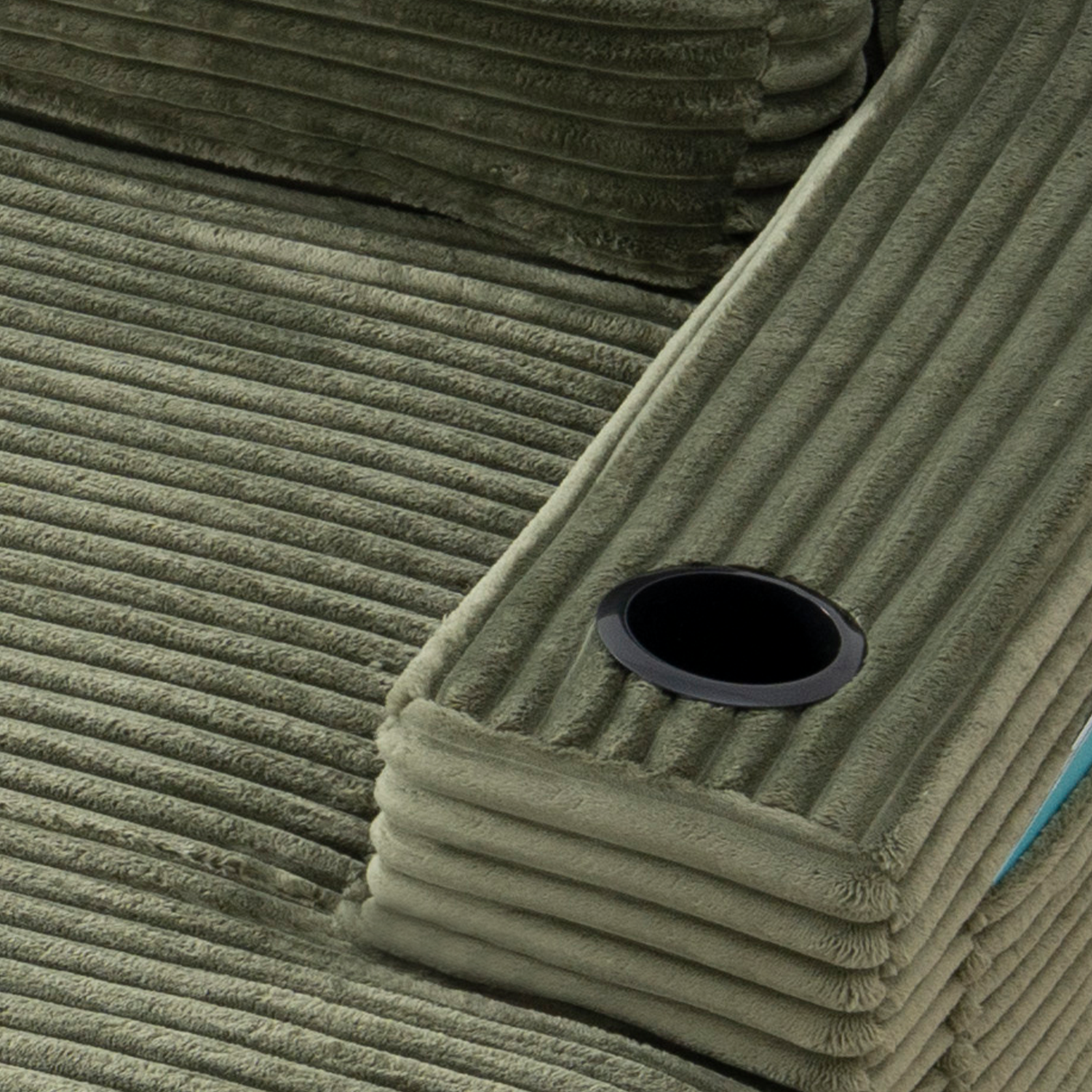 Green corduroy chaise with built-in cup holder opening in the armrest