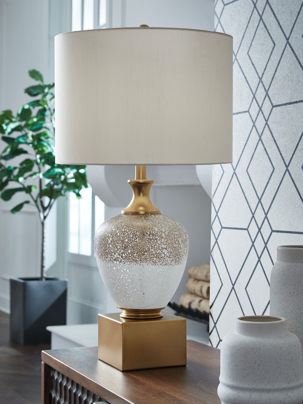 Glass table lamp with white drum shade, speckled white-and-gold glass body.