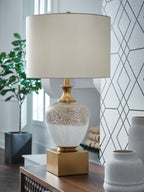 Glass table lamp with white drum shade, speckled white-and-gold glass body.