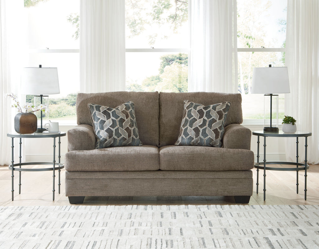 Light beige fabric loveseat with two geometric patterned pillows