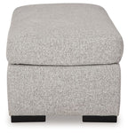 Light gray upholstered ottoman with rounded cushioned top and dark legs