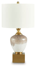 Glass table lamp with gold base, brown-speckled white body, white drum shade.