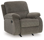 Dark gray rocker recliner chair with high backrest, rounded arm cushions, and base
