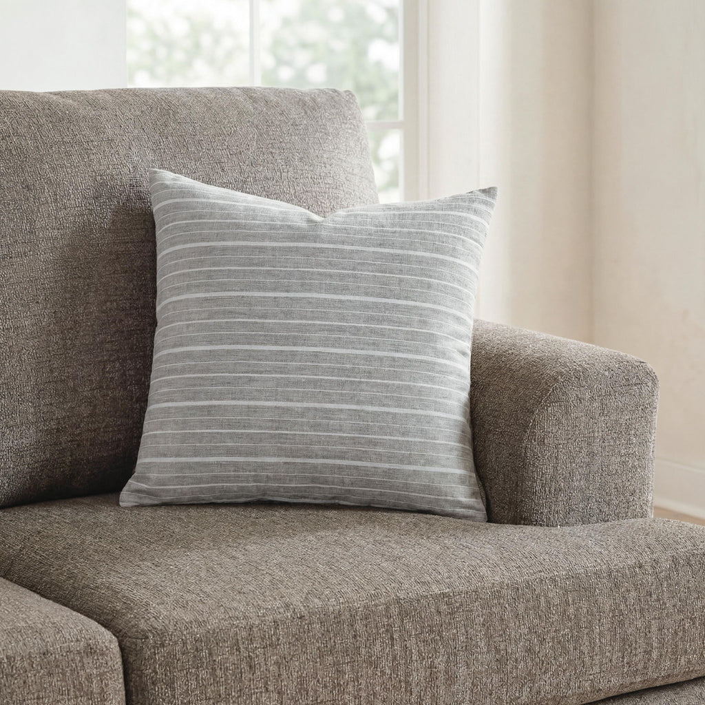 Gray striped throw pillow with thin horizontal lines on a cushioned seat