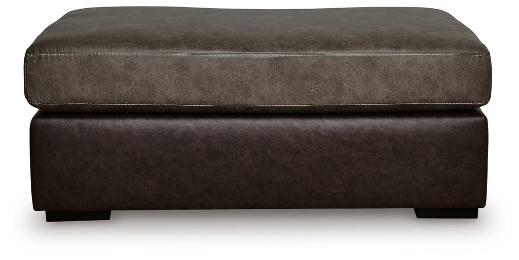 Oversized accent ottoman side view with padded top and dark brown fabric base.