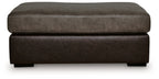 Oversized accent ottoman side view with padded top and dark brown fabric base.