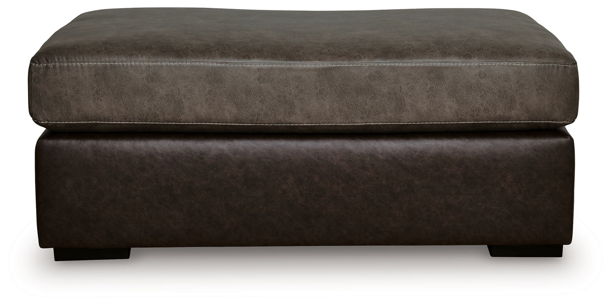 Oversized accent ottoman side view with padded top and dark brown fabric base.