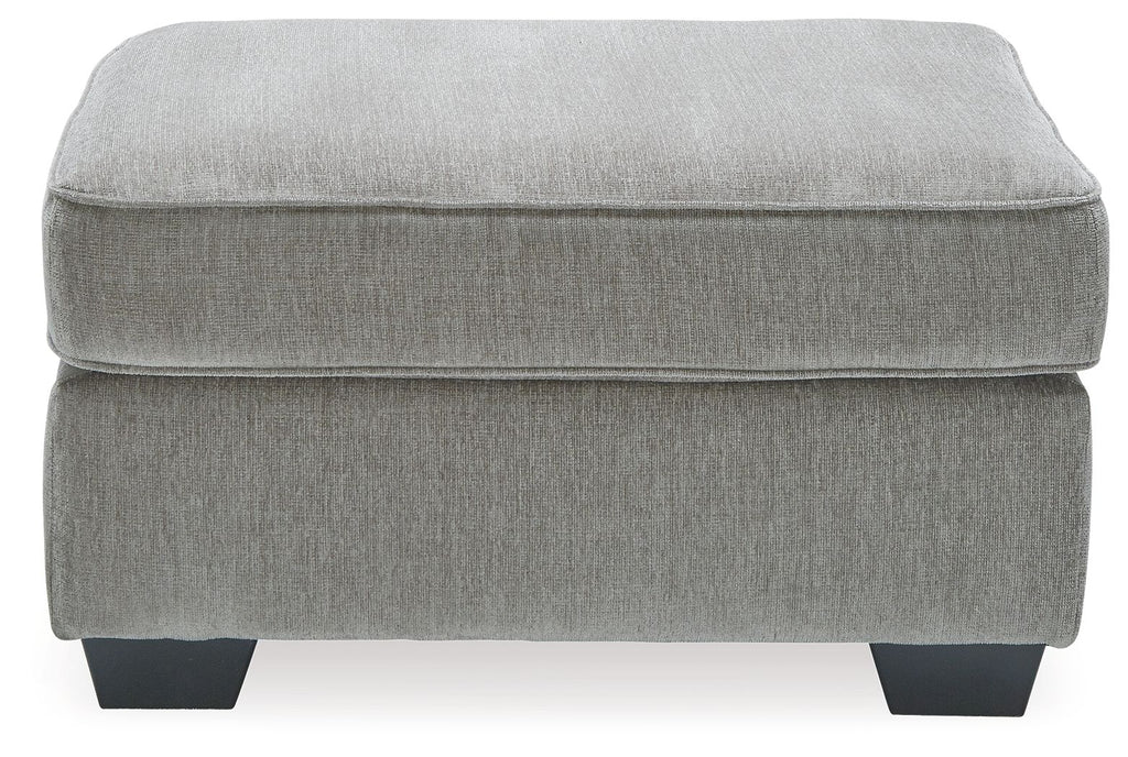 Light gray upholstered accent ottoman with smooth padded seat and short block legs