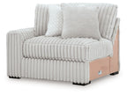 Upholstered corner chair with ribbed light-gray fabric, three cushions, and wooden base panel