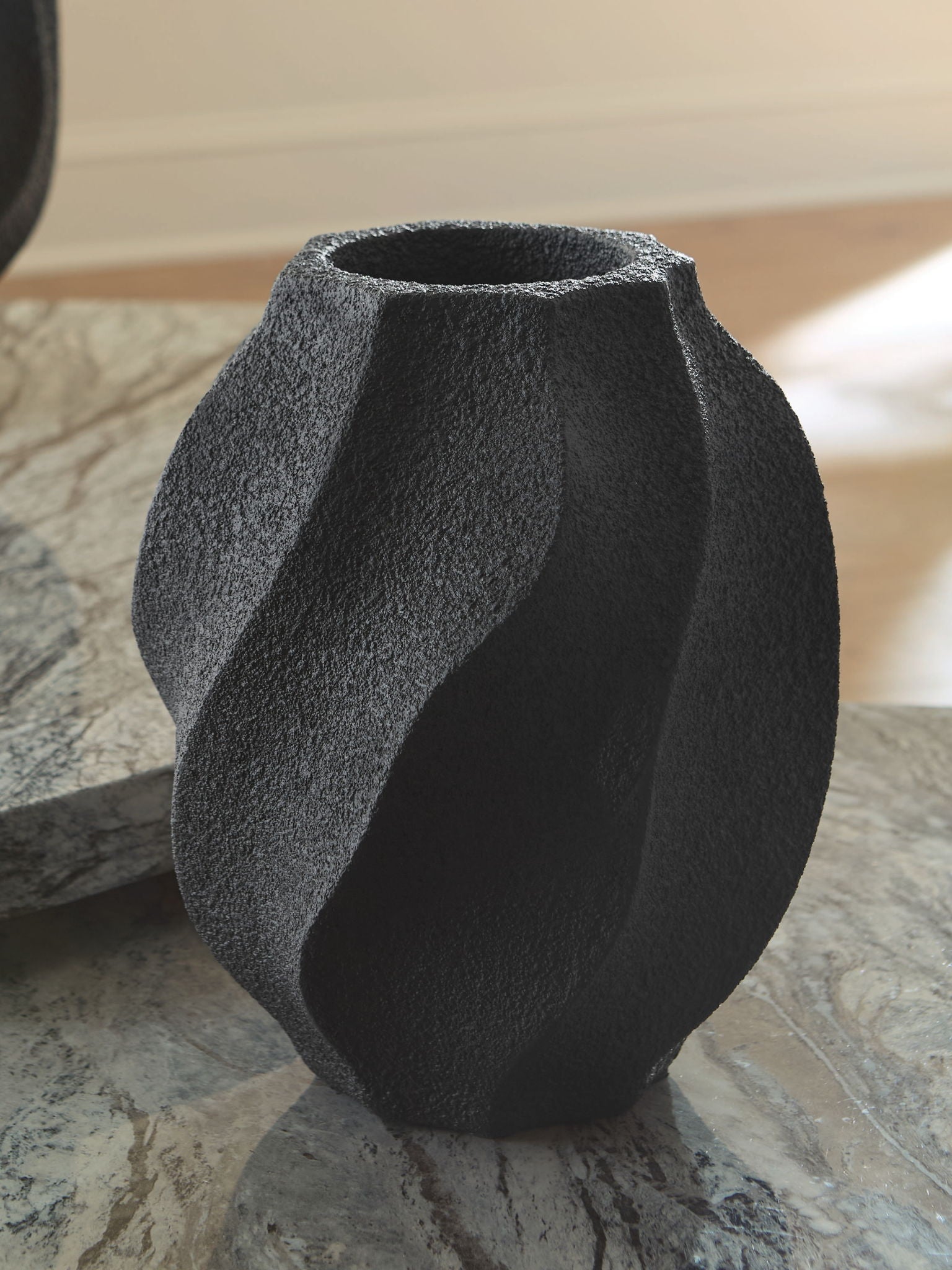 Black textured vase with fluted curves and narrow round mouth