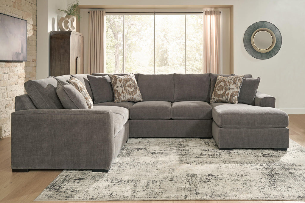 Gray L-shaped sectional sofa with chaise and patterned throw pillows