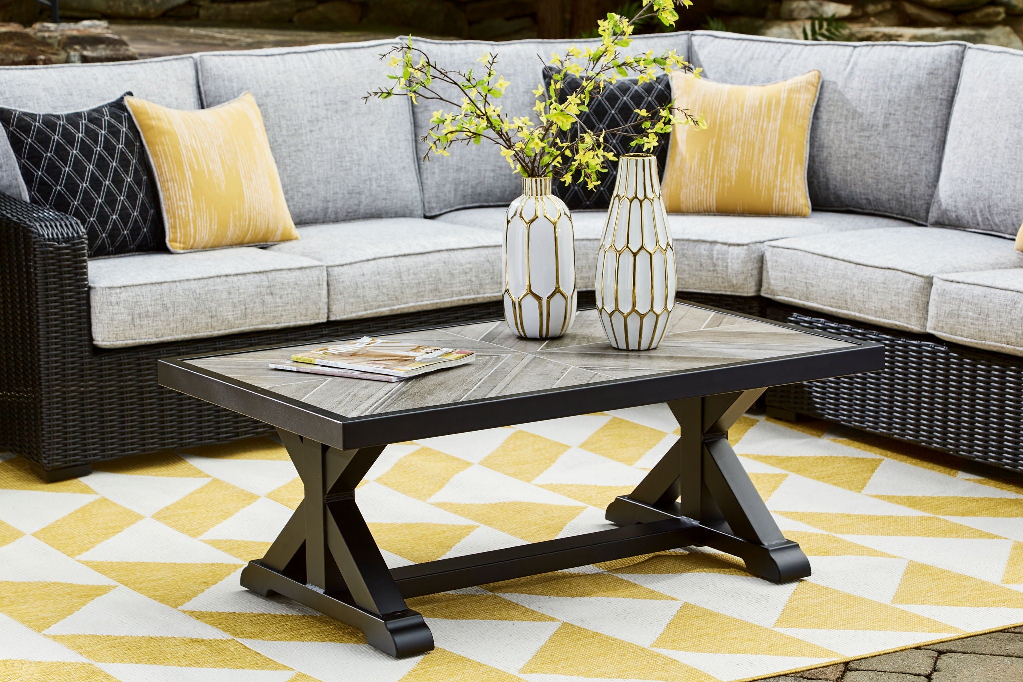 Rectangular cocktail table with black base and light gray top, styled with flowers