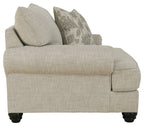 Light gray linen-style armchair side view with two throw pillows and cushioned seat